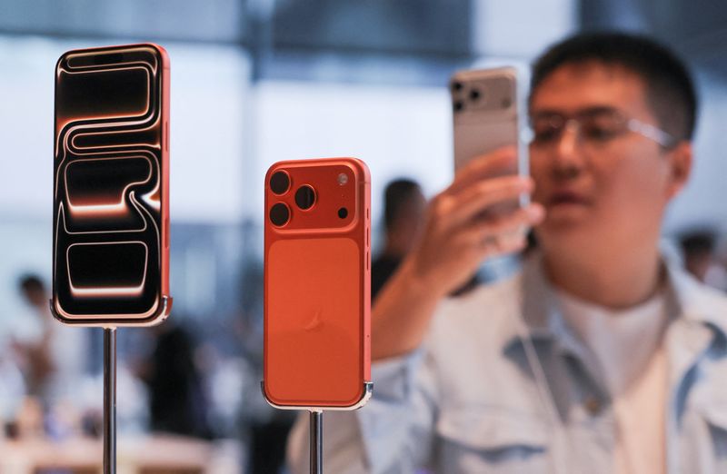 FILE PHOTO: A man takes images of the new iPhone 17 Pro smartphones as they are displayed at the Apple store in Beijing's Sanlitun area during the start of sales in Beijing, China September 19, 2025. REUTERS/Maxim Shemetov/File Photo
