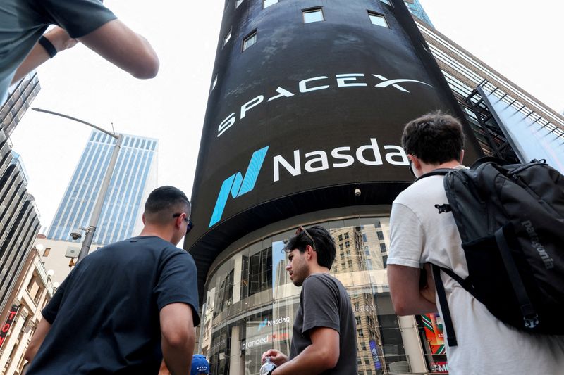 People gather near a SpaceX advertisement outside the Nasdaq MarketSite, on the day of their initial public offering (IPO) in New York City, U.S., June 12, 2026. REUTERS/Brendan McDermid