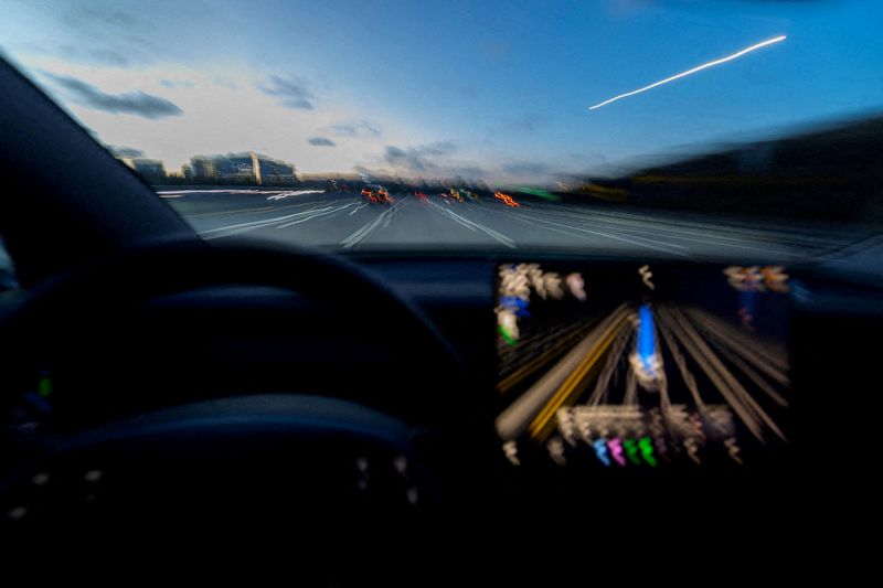 FILE PHOTO: A display of a Tesla Model 3 using Full Self-Driving Supervised on a highway in San Diego, California, U.S., April 15, 2026. Picture taken with a long exposure. REUTERS/Mike Blake//File Photo