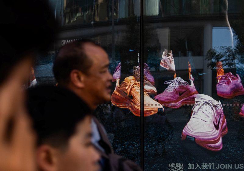 People walk past a showcase of Nike store on Wangfujing street in Beijing, China August 7, 2025. REUTERS/Maxim Shemetov