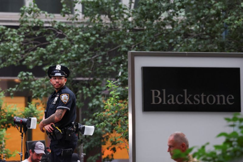 A police officer stands next a logo of Blackstone, near the scene of a deadly mass shooting in Manhattan, New York City, U.S. July 29, 2025. REUTERS/Mike Segar