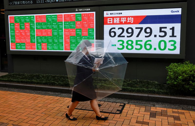 A pedestrian walks past a stock quotation board showing the Nikkei share average outside a brokerage in Tokyo, Japan, July 17, 2026. REUTERS/Manami Yamada     TPX IMAGES OF THE DAY