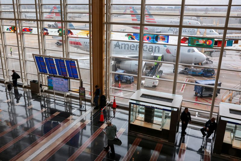 FILE PHOTO: American Airlines planes sit on the tarmac as a person moves through Ronald Reagan Washington National Airport, as the Department of Homeland Security (DHS) continues to go unfunded, in Arlington, Virginia, U.S., March 16, 2026. REUTERS/Kylie Cooper/File Photo
