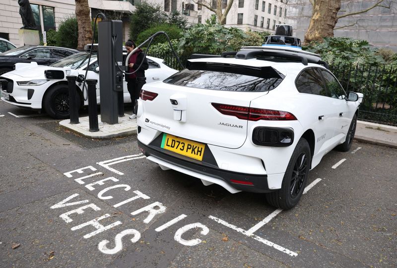 A test and safety driver charges a Waymo autonomous vehicle parked at an electric charging point, during on the road trialling and mapping, ahead of an anticipated rollout of the robotaxi service later in the year, in London, Britain, March 13, 2026. REUTERS/Toby Melville