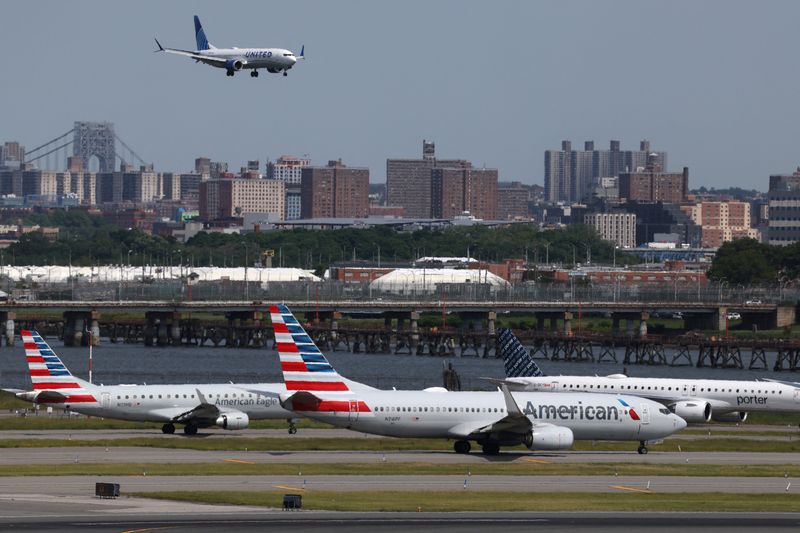 FILE PHOTO: Planes cue on the runway for takeoff as another lands at New York's LaGuardia airport in New York City, U.S., May 22, 2026. REUTERS/Shannon Stapleton/File Photo
