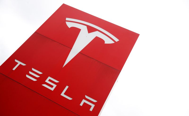 The logo of car manufacturer Tesla is seen at a dealership in London, Britain, May 14, 2021. REUTERS/Matthew Childs/File Photo
