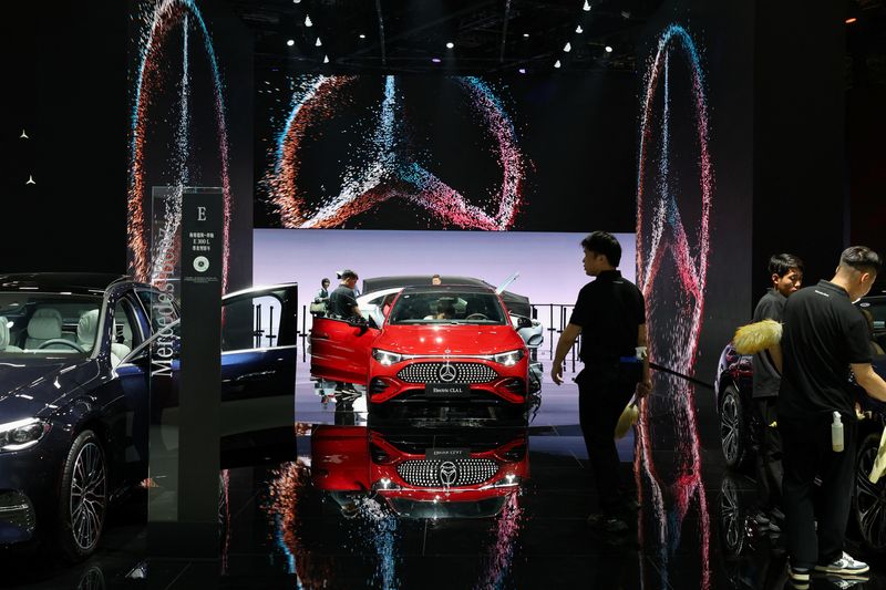 Workers clean cars at the Mercedes-Benz booth during a media day for the Auto Shanghai show in Shanghai, China April 24, 2025. REUTERS/Go Nakamura