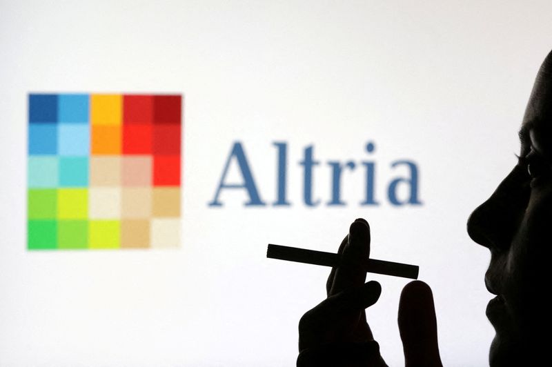 FILE PHOTO: A woman poses with a cigarette in front of Altria logo in this illustration taken July 26, 2022. REUTERS/Dado Ruvic/Illustration/File Photo