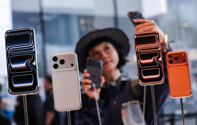 A woman takes a selfie with iPhones inside the Apple store in Beijing's Sanlitun area as the new iPhone 17 series smartphones go on sale in Beijing, China September 19, 2025. REUTERS/Maxim Shemetov