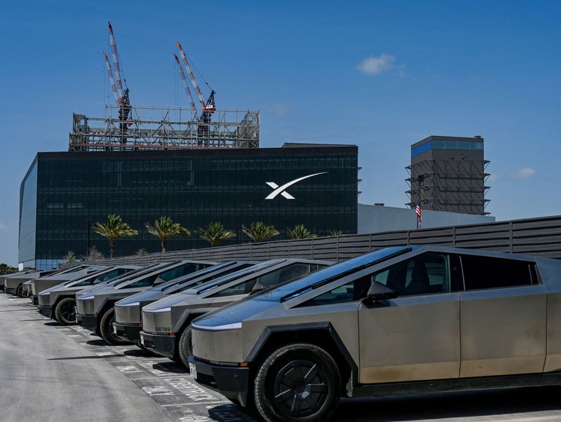 FILE PHOTO: A fleet of Tesla Cyber trucks is parked at charging stations outside the SpaceX launch production facility in Starbase, Texas, U.S., July 20, 2026. REUTERS/Steve Nesius/File Photo