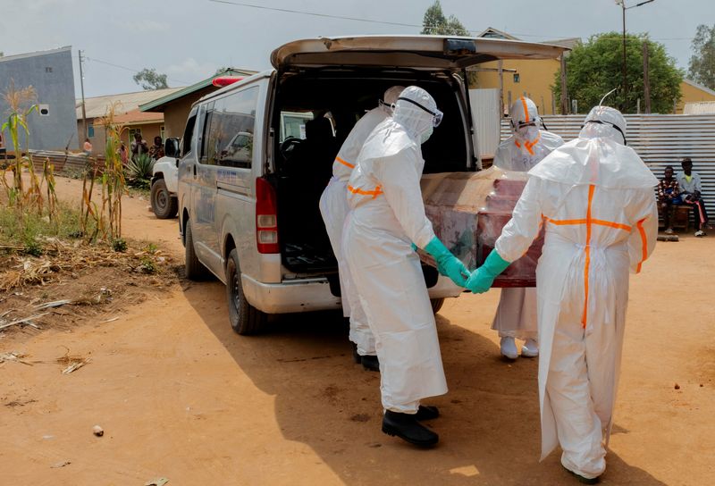 Members of the Civil Protection, a local community-based team that works to help mitigate the spread of the Ebola virus and ensure burials happen safely and quickly, wearing personal protective equipment (PPE), carry a wooden coffin before loading the body of an unidentified man, who according to his family, died of Ebola, as they attend to retrieve it from his house, as aid agencies intensify efforts to contain a new Ebola outbreak involving the Bundibugyo strain, in Bunia, Ituri province, Democratic Republic of Congo, July 10, 2026. REUTERS/Gradel Muyisa Mumbere