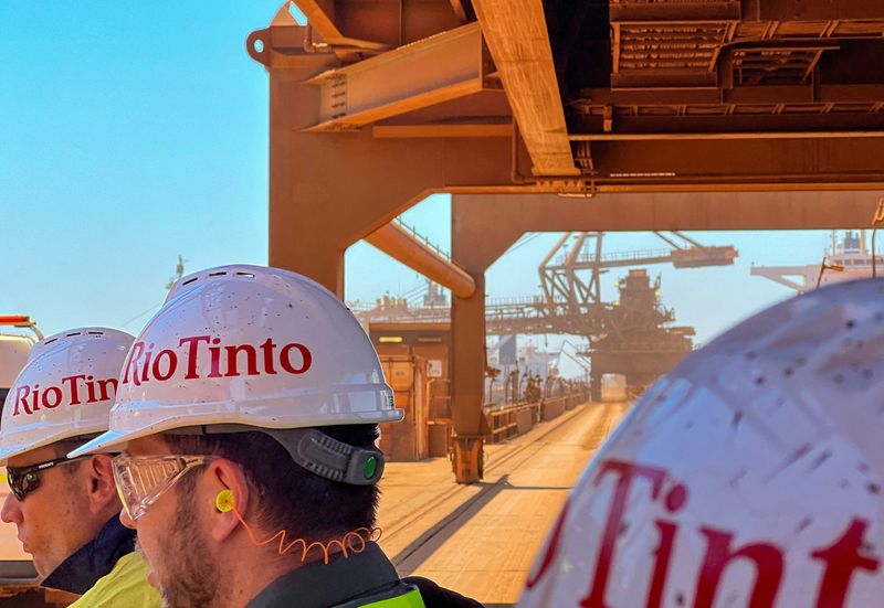 FILE PHOTO: Visitors to Rio Tinto's iron ore export port of Dampier walk in front of a loader transferring iron ore into a bulk carrier, in Port Dampier, 1,250 kilometres (777 miles) northeast of Perth, Australia October 20, 2023. REUTERS/Melanie Burton/File Photo