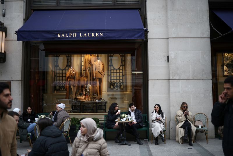 FILE PHOTO: People sit outside a Ralph Lauren store on New Bond Street in London, Britain, March 11, 2023. REUTERS/Henry Nicholls/ File Photo