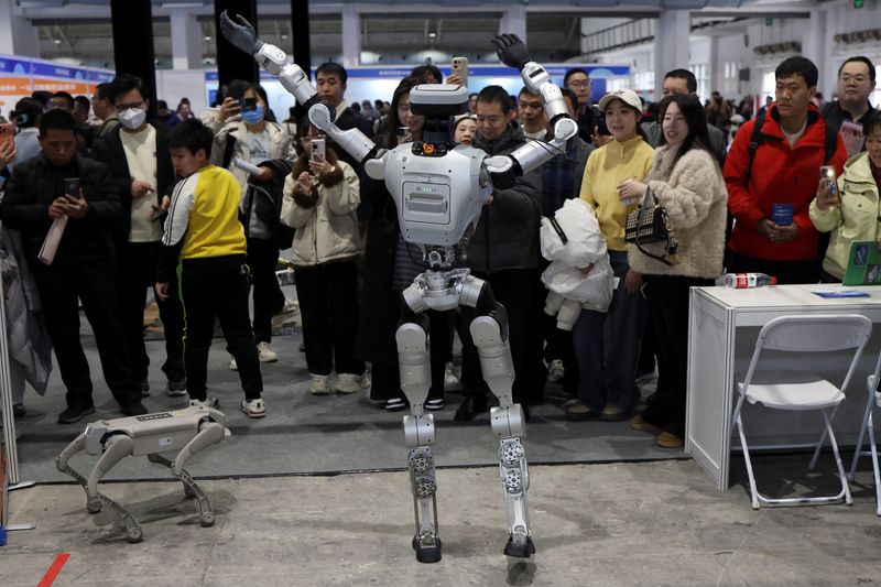 A humanoid robot dances in front of visitors at a job fair in Beijing, China March 14, 2026. REUTERS/Florence Lo