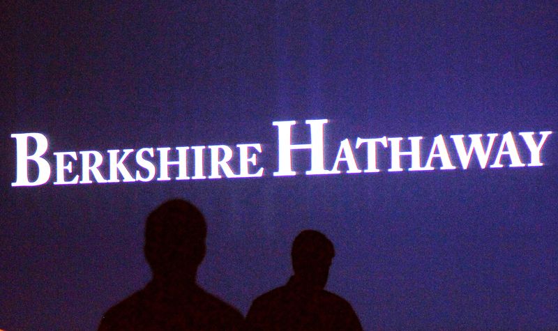 FILE PHOTO: Berkshire Hathaway shareholders walk by a video screen at the company's annual meeting in Omaha May 4, 2013. REUTERS/Rick Wilking/File Photo
