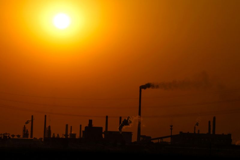 FILE PHOTO: Factories are silhouetted during sunset, in Handan, Hebei province, China April 7, 2026. REUTERS/Tingshu Wang/File Photo