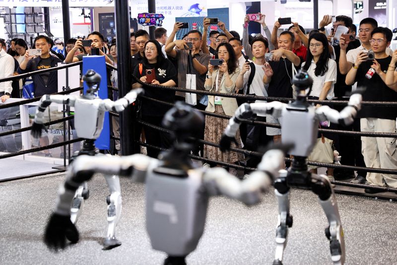 FILE PHOTO: People watch humanoid robots dance at the Unitree booth during the World Artificial Intelligence Conference (WAIC) in Shanghai, China, July 17, 2026. REUTERS/Go Nakamura/File Photo