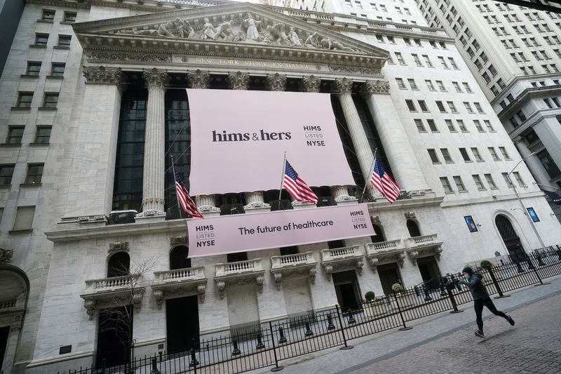 FILE PHOTO: The New York Stock Exchange with a Hims & Hers Health, Inc banner is pictured as a person runs past in the Manhattan borough of New York City, New York, U.S., January  21, 2021. REUTERS/Carlo Allegri/File Photo