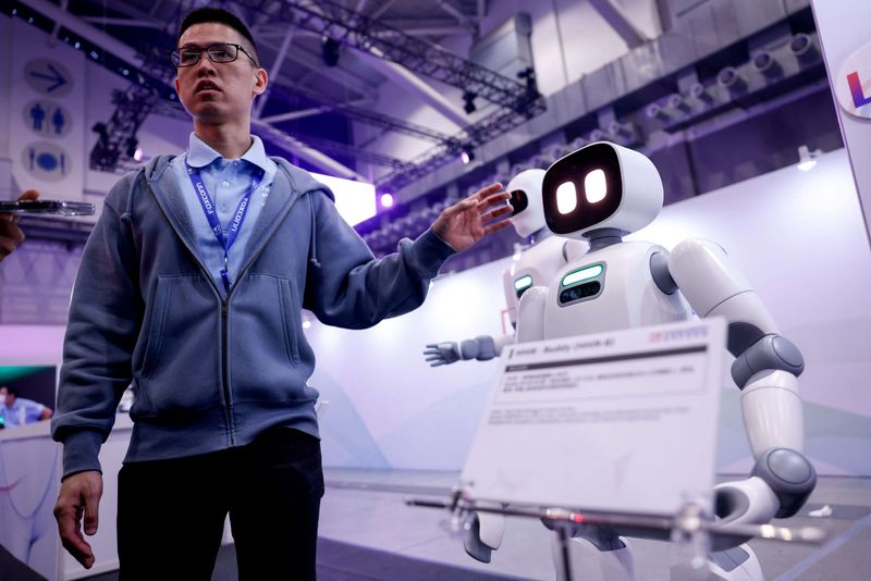 A man stands near robots displayed at Foxconn’s annual tech day in Taipei, Taiwan, November 21, 2025. REUTERS/Ann Wang