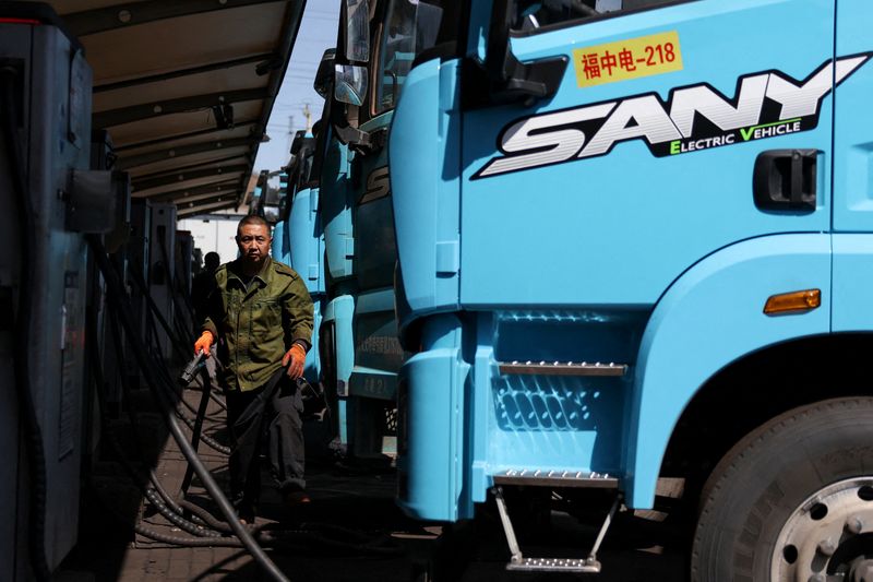 FILE PHOTO: A driver uses a charging station to charge a Sany electric heavy truck at a fleet depot equipped with electric truck charger, in Tangshan, Hebei province, China, April 1, 2026. REUTERS/Tingshu Wang/File Photo