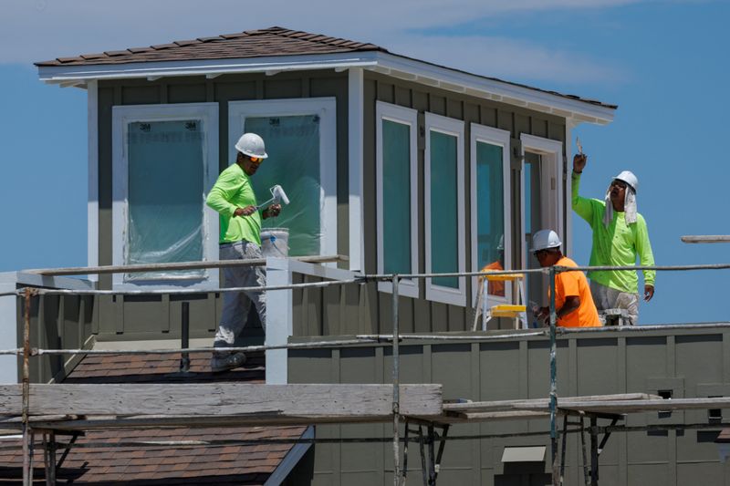 Construction workers paint a residential housing project during a heat wave, in Carlsbad, California, U.S. July 8, 2025.  REUTERS/Mike Blake