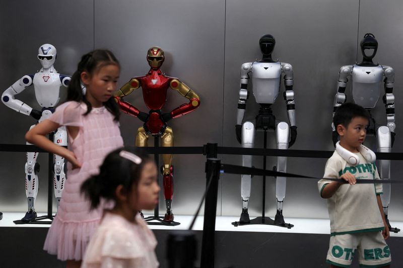 FILE PHOTO: Children stand near Unitree's humanoid robots on display at a Unitree store in Beijing, China August 10, 2026. REUTERS/Tingshu Wang/File Photo