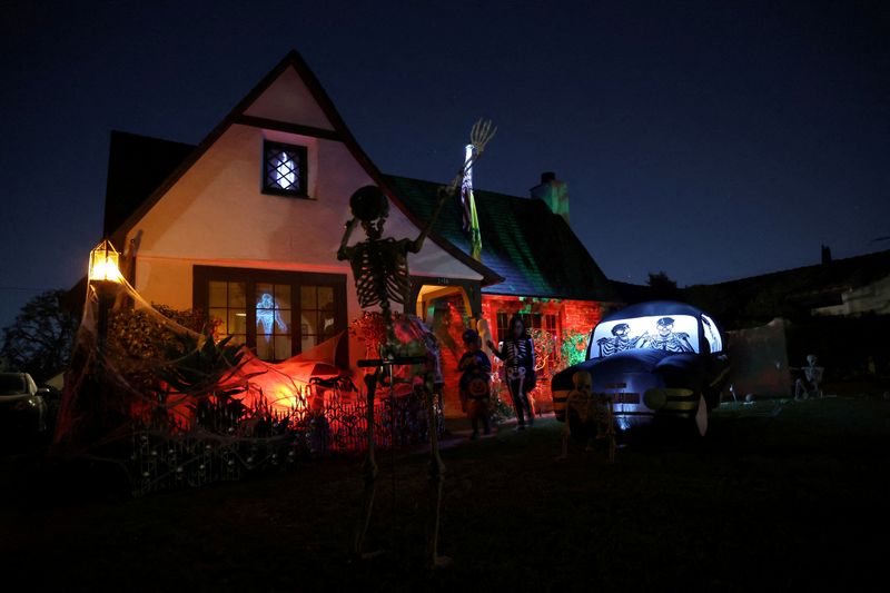 FILE PHOTO: People wearing costumes go trick-or-treating by a decorated house on Halloween night in Pasadena, California, U.S., October 31, 2024. REUTERS/Mario Anzuoni/File Photo
