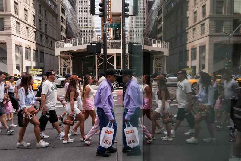 People walk on Fifth Avenue as President Trump’s new tariffs are imposed, in New York City, U.S., August 7, 2025. REUTERS/Adam Gray