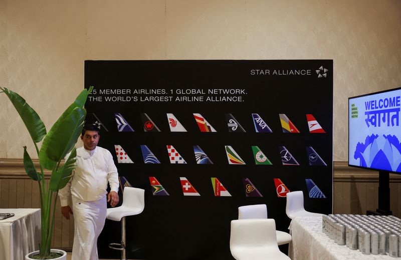 A waiter walks past a board displaying member airlines of the Star Alliance network during the annual International Air Transport Association (IATA) meeting in New Delhi, India, June 2, 2025. REUTERS/Anushree Fadnavis