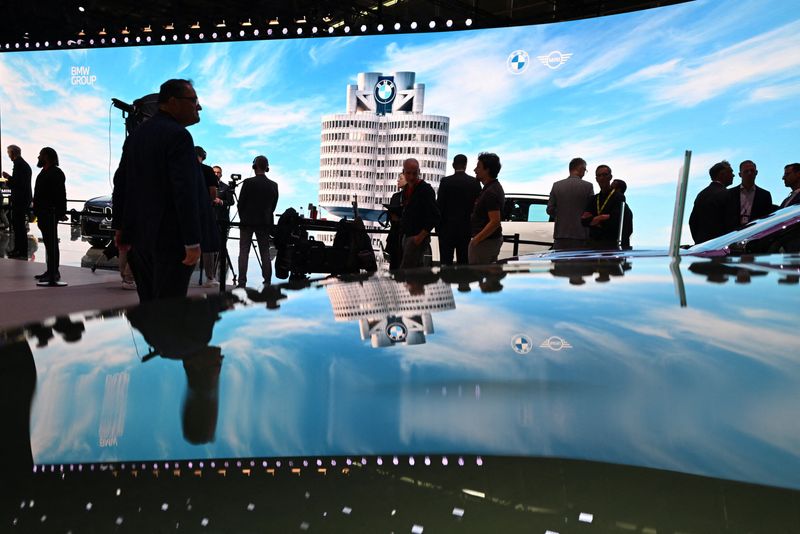People stand next to BMW vehicles displayed during the press and media day of the IAA auto show in Munich, Germany, September 8, 2025. REUTERS/Angelika Warmuth