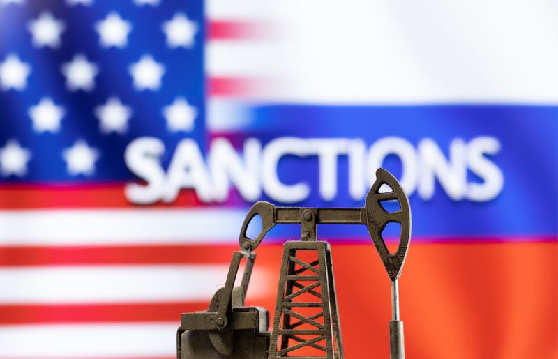 A model of a pump jack is seen in front of the displayed word "Sanctions",  U.S. and Russia flag colours in this illustration taken March 8, 2022. REUTERS/Dado Ruvic/Illustration