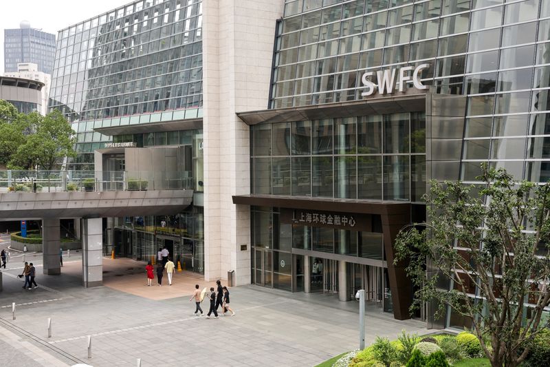 FILE PHOTO: People walk outside Shanghai World Financial Center, where a Wells Fargo office is situated, in the Lujiazui financial district in Shanghai, China, July 18, 2025.  REUTERS/Go Nakamura/File Photo