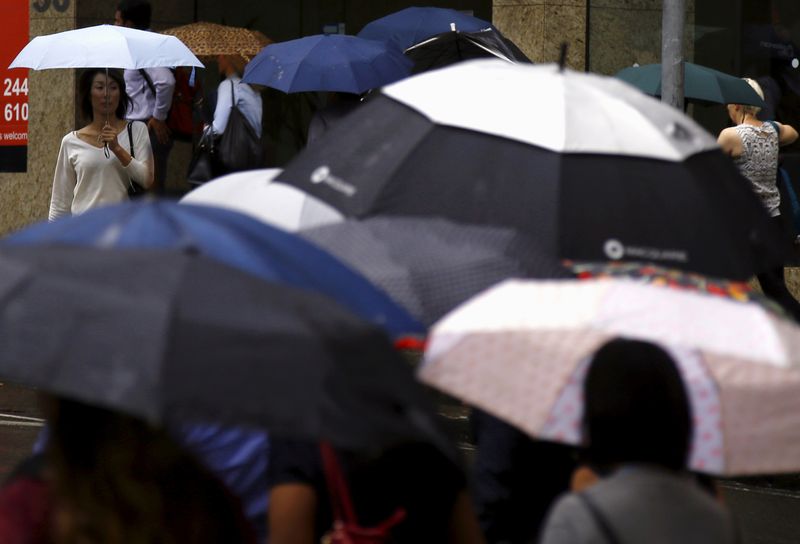 Pedestrians hold umbrellas as they walk to office buildings on a rainy morning in central Sydney, Australia, April 4, 2016. REUTERS/David Gray/File Photo