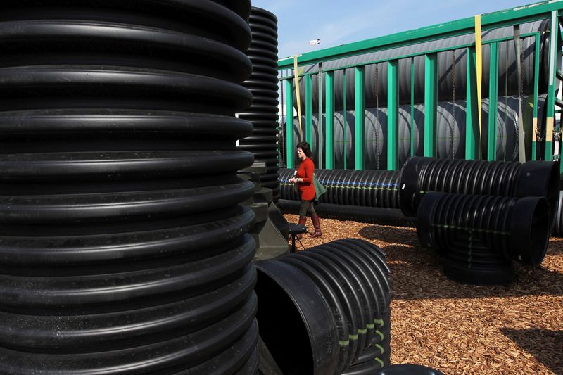 FILE PHOTO: A woman walks among rain pipes at the Advanced Drainage Systems exhibit area at the 47th Annual World Ag Expo in Tulare, California, February 12, 2014.   REUTERS/David McNew/File Photo