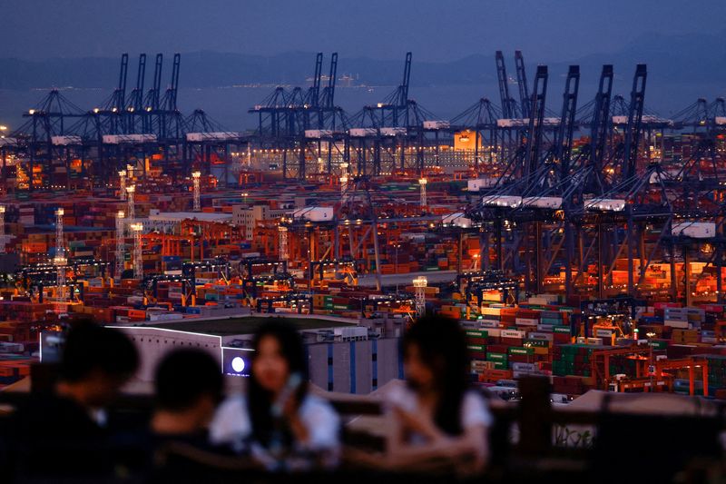 FILE PHOTO: People enjoy their time on a hill overlooking Yantian port in Shenzhen, Guangdong province, China May 9, 2025. REUTERS/Tingshu Wang     TPX IMAGES OF THE DAY/File Photo