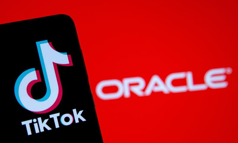 A smartphone with the Tik Tok logo is seen in front of a displayed Oracle logo in this illustration taken, Septemeber 14, 2020. REUTERS/Dado Ruvic/Illustration/File Photo