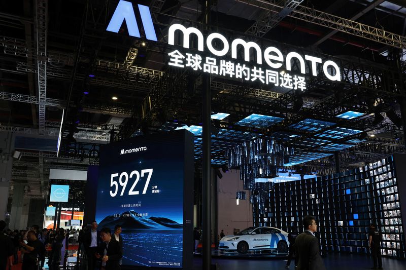 FILE PHOTO: People walk past the booth of Chinese autonomous driving startup Momenta during a media day for the Auto Shanghai show in Shanghai, China April 23, 2025. REUTERS/Go Nakamura/File Photo