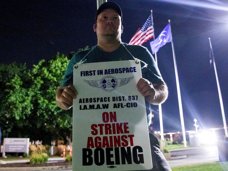 FILE PHOTO: A worker holds a picket sign, as people protest during a walkout by members of the International Association of Machinists and Aerospace Workers (IAM) over contract negotiations, outside Boeing company's facility, in Berkeley, Missouri, U.S., August 4, 2025 REUTERS/Lawrence Bryant/File Photo