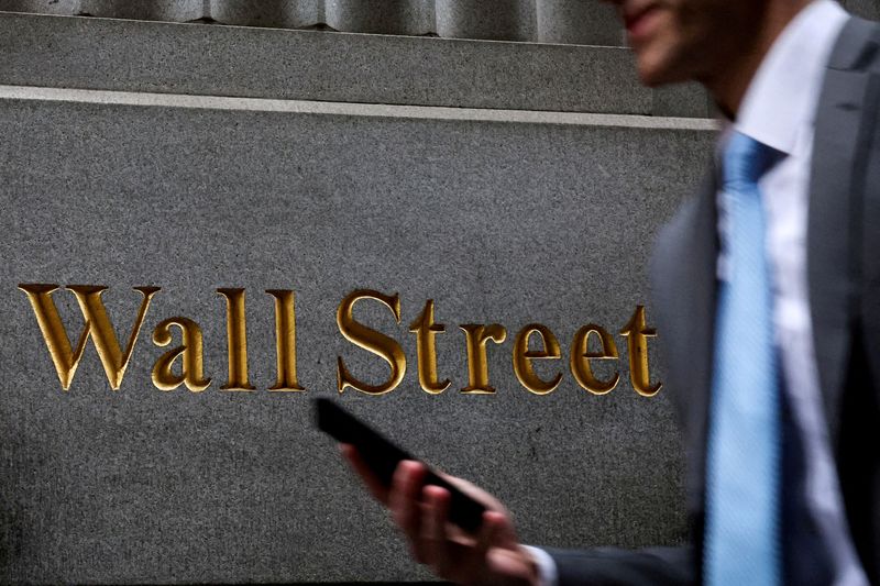 FILE PHOTO: A man walks on Wall Street outside the New York Stock Exchange (NYSE) in New York City, U.S., April 7, 2025. REUTERS/Brendan McDermid/File Photo