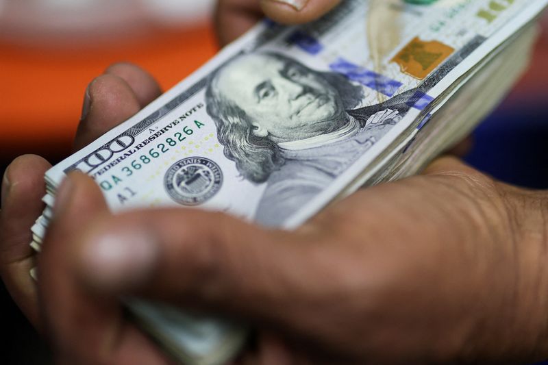 An employee shows a hundred U.S. dollar bill in an exchange house, in Bogota, Colombia January 27, 2025. REUTERS/Luisa Gonzalez