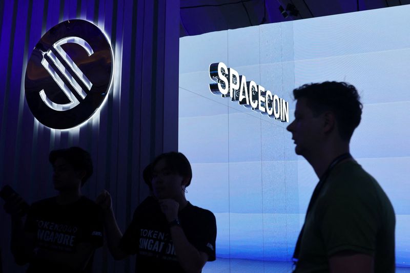 An attendee walks past the Spacecoin booth at the TOKEN2049 crypto conference in Singapore October 1, 2025. REUTERS/Edgar Su