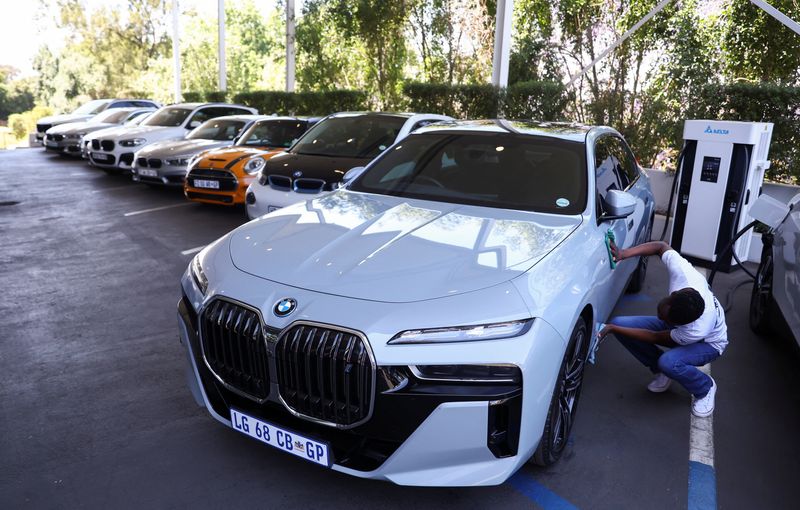 A worker cleans a BMW i7 xDrive60 elecric car while it is charging at a BMW dealership in Sandton, South Africa,  October 27, 2023. REUTERS/Siphiwe Sibeko