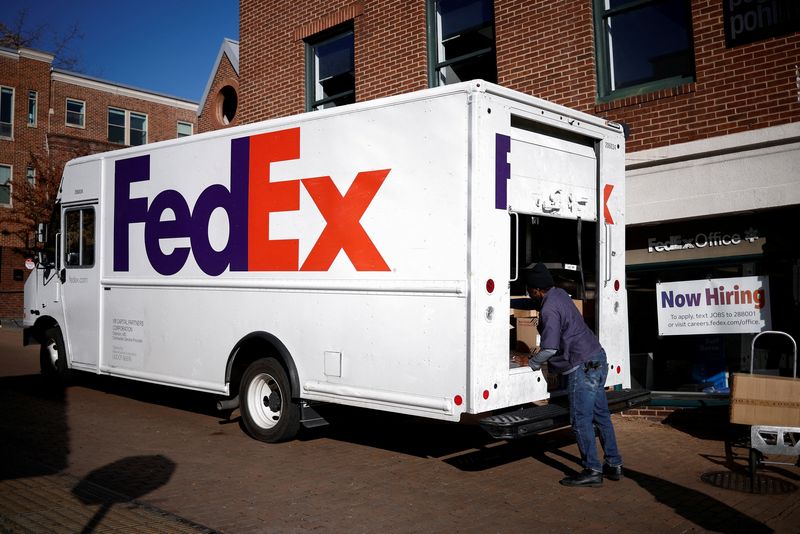 FILE PHOTO: A driver of FedEx loads packages into a delivery truck during Black Friday preparations in the Georgetown neighborhood of Washington, U.S., November 26, 2024. REUTERS/Benoit Tessier/File Photo