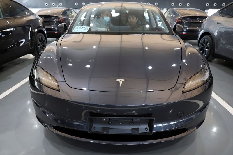 Customers sit in a Tesla Model Y electric vehicle (EV) at the carmaker's delivery centre in Beijing, China January 8, 2025. REUTERS/Florence Lo