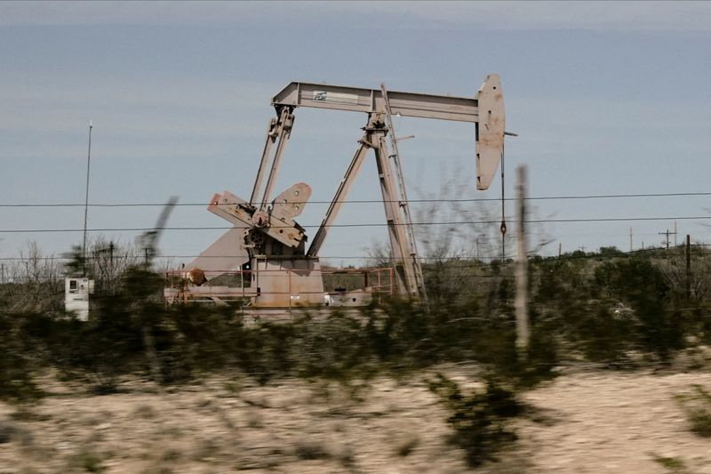 FILE PHOTO: A pump jack drills oil crude from the Yates Oilfield in West Texas' Permian Basin near Iraan, Texas, U.S., March 17, 2023. Picture taken through glass. REUTERS/Bing Guan/File Photo