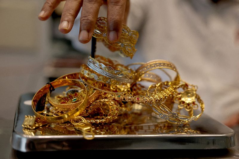 FILE PHOTO: A goldsmith weighs gold jewellery inside a showroom in Ahmedabad, India, July 31, 2025. REUTERS/Amit Dave//File Photo