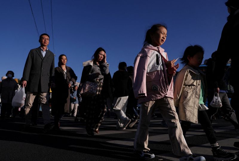 FILE PHOTO: People walk on a street in Beijing, China October 19, 2025. REUTERS/Tingshu Wang/File Photo