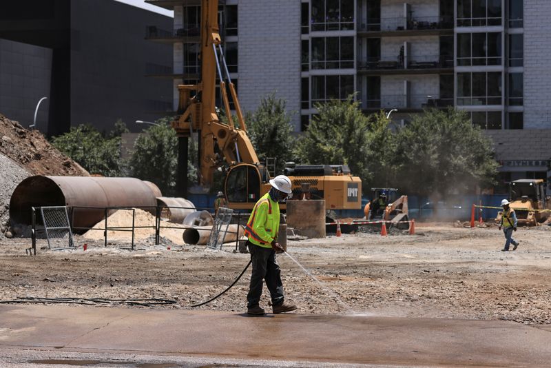 FILE PHOTO: A construction worker sprays the entrance to a construction site to prevent dusty conditions as extreme heat hits Texas, in Austin, Texas, U.S., June 17, 2022. REUTERS/Jordan Vonderhaar