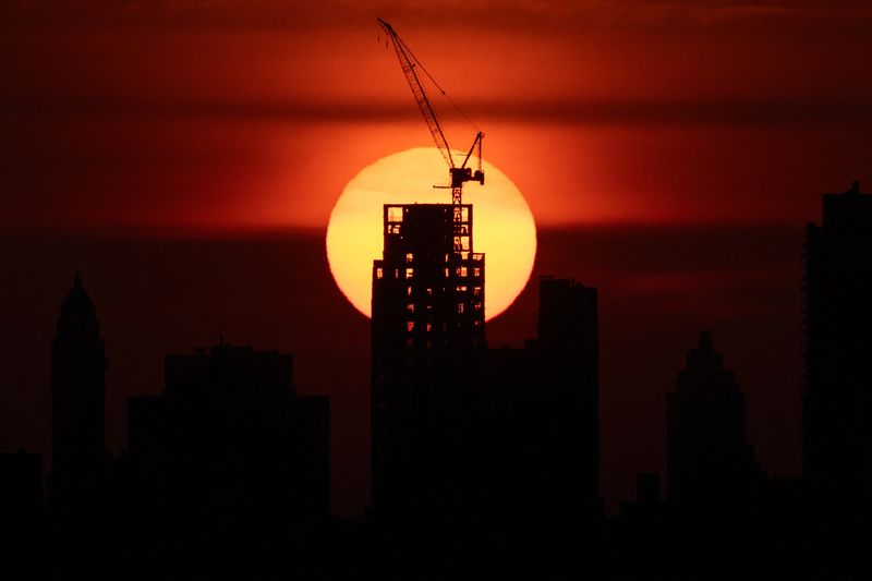 The sun sets behind the Manhattan skyline as an extreme heat warning is in effect in New York City, U.S., June 23, 2025. REUTERS/Kylie Cooper