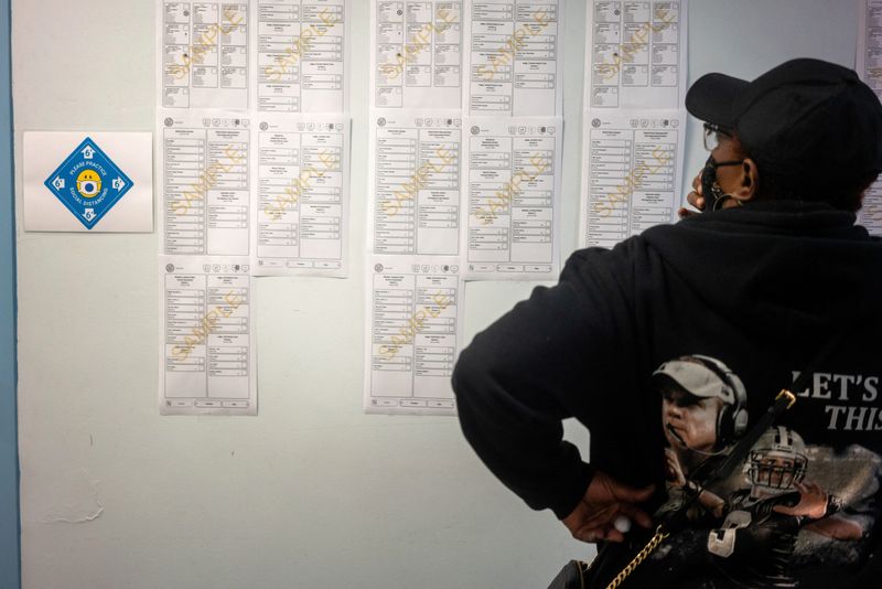 FILE PHOTO: A woman looks at sample ballots while waiting at City Hall to cast her ballot for the upcoming presidential election as early voting begins in New Orleans, Louisiana, U.S., October 16, 2020. REUTERS/Kathleen Flynn/File Photo